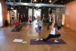 Anna Limauro (foreground) of Carmel teaches a yoga class at Blooming Life Yoga Studio in Zionsville. Limauro is among the youngest yoga instructors in the state. (Photo by Theresa Skutt) ￼