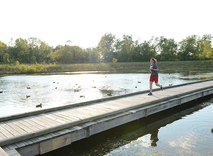 Melanie Brown runs across a bridge in West Park. She is training for two half marathons this fall after recovering from an illness that left her paralyzed in 2014. (Photo by Theresa Skutt)