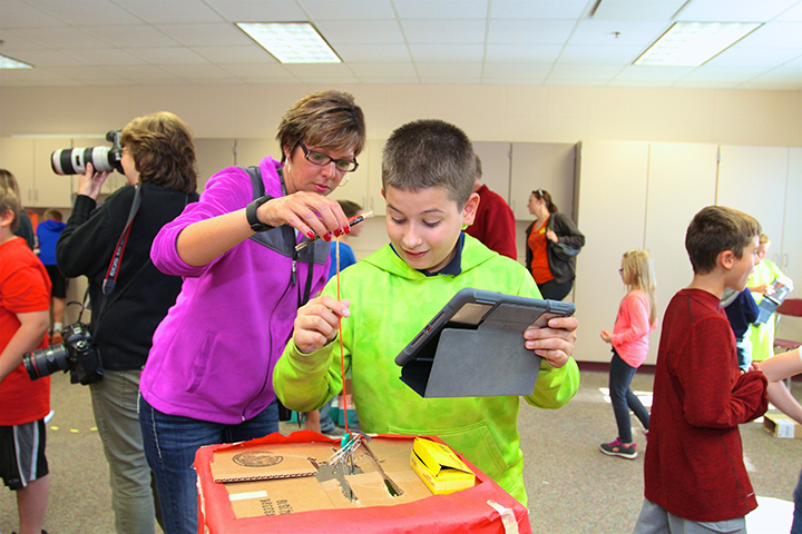 Principal Heather Noesges plays the arcade game of Gabriel Todd, 11, a fifth grader. (Photo by Sadie Hunter)