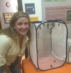 Amanda Smith pauses by some monarchs in the nature center. (Photo by Anna Skinner)