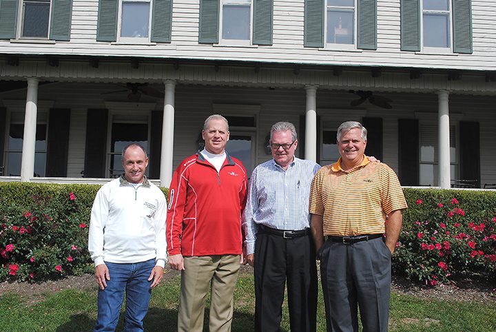From left, Mark Thompson, Matt Cohoat, David Compton and Doc O’Neal pause by a rendering of the amenity center shown in the clubhouse. (Photo by Anna Skinner)