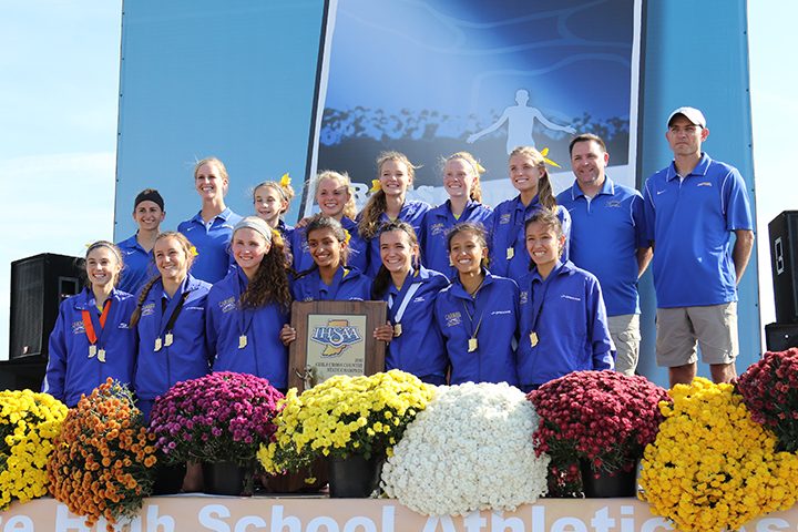 The Carmel girls cross country team holds up the state championship trophy. (Submitted photo)