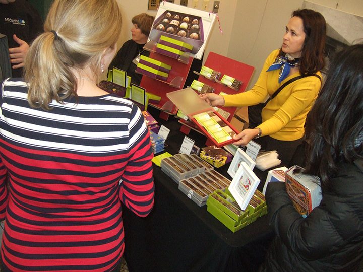 Joann Hofer of Xchocol’Art speaks with guests at the 2015 Green Gift Shop. (Submitted photo)