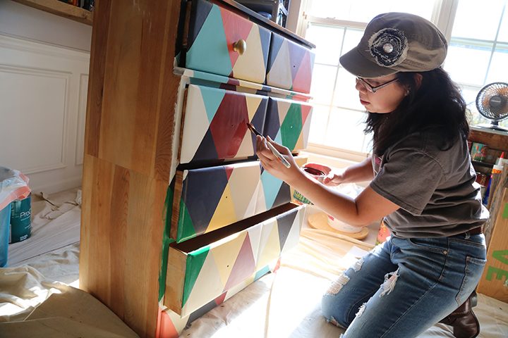Meaghan Wolf, founder of Metamorphosis Design, paints furniture in her Carmel home. (Photo by Ann Marie Shambaugh)