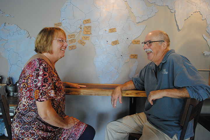 Tony and Debbie Zancanaro converse in front of a map of Africa depicting all the wells that The Well has funded. (Photo by Anna Skinner)