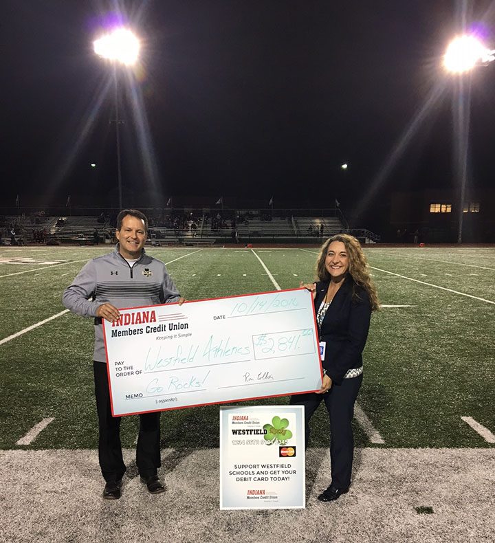 The Indiana Members Credit Union contributed $2,841 to Westfield High School last month in part with an ongoing school spirit debit card program. Westfield fans can sign up for a Rocks-themed debit card, and each time the card is used, Westfield athletics benefit from the transaction. Athletic Director Bill Davis, left, receives the check from Gina Terril, IMCU senior business development officer. (Submitted photo)   