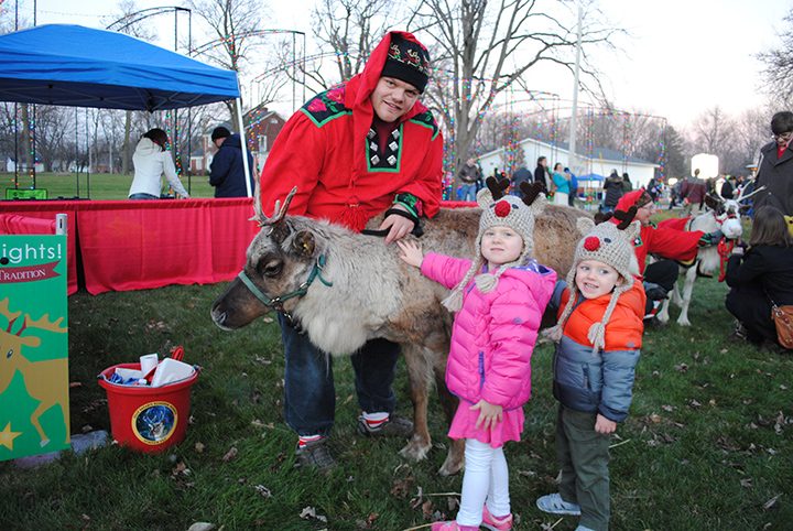 Lauren, middle, and Bradley Zelik pet Sven the reindeer at last year’s Westfield in Lights. Two reindeer will be present this year. (File photo)
