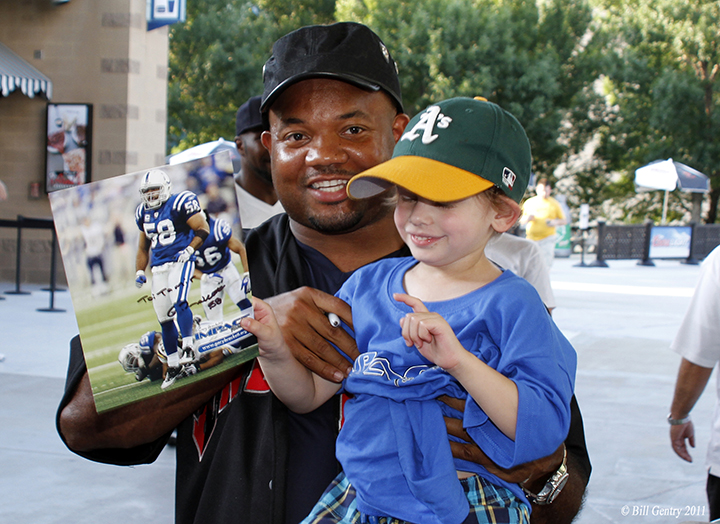 Gary Brackett pauses with a young fan after signing an autograph. Brackett has been active in the Indianapolis community since leaving football in 2011. (Submitted photo)