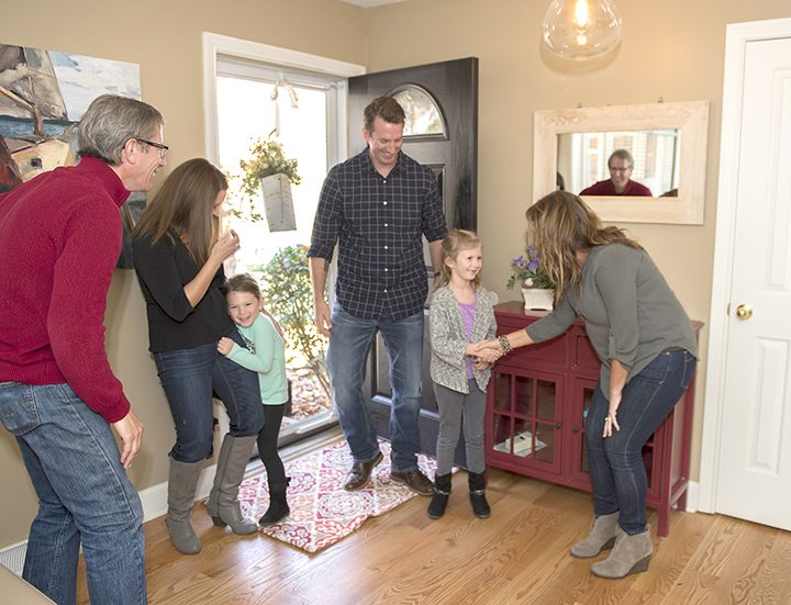 Homeowners Karen Kedanis, right, and her husband, Michael, left, greet guests Gama, Joss, Justin and Sloan Kramer. The family rented the Carmel house through Airbnb. (Photo by Theresa Skutt)