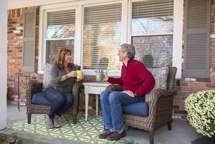 Karen and Michael Kedanis enjoy drinks on their front porch, a space they said is a favorite for guests. (Photo by Theresa Skutt)