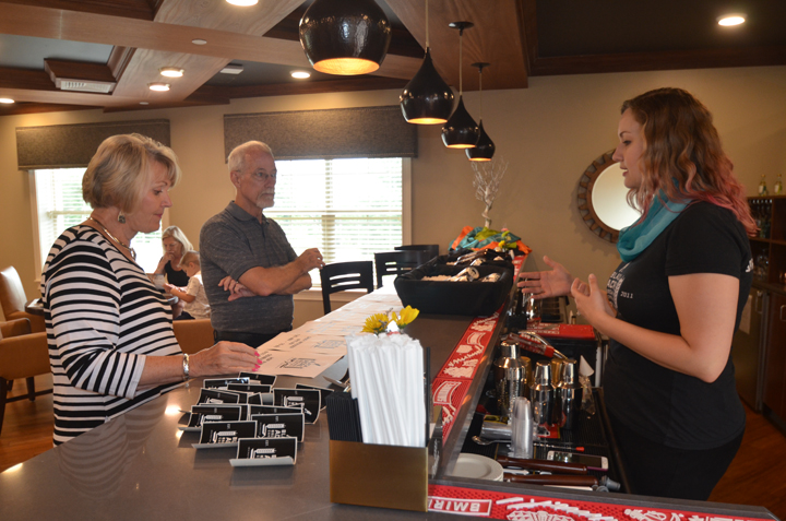 Holly Miller, owner of Black Acre Brewing Co. and clinical director for Freedom Home Health, serves beer samples to event attendees Janet Kuebler and Ted Richey. (Photo by Sara Baldwin)