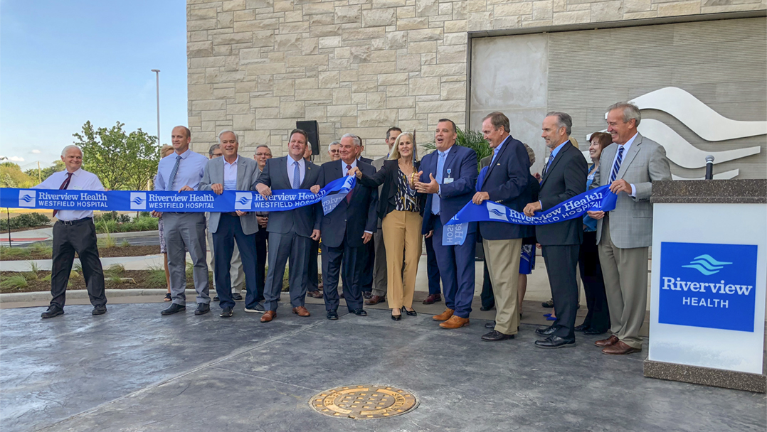 Riverview Health CEO Seth Warren is joined by Hamilton County commissioners, Westfield City Council members, Mayor Andy Cook and others as he cuts the ribbon for Riverview Health Westfield Hospital. (Photo by Anna Skinner)