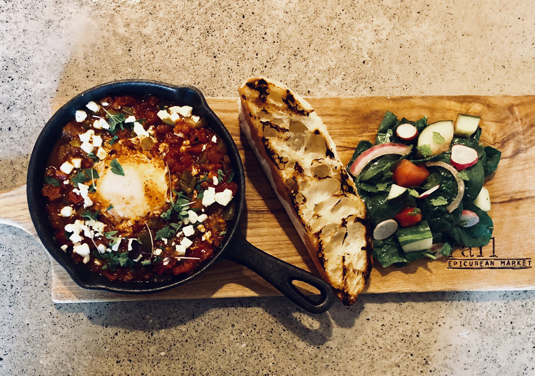 The Rail Epicurean’s Shakshuka is a Middle Eastern dish paired with a grilled baguette and fresh, locally sourced spinach salad. (Photo by Anna Skinner)