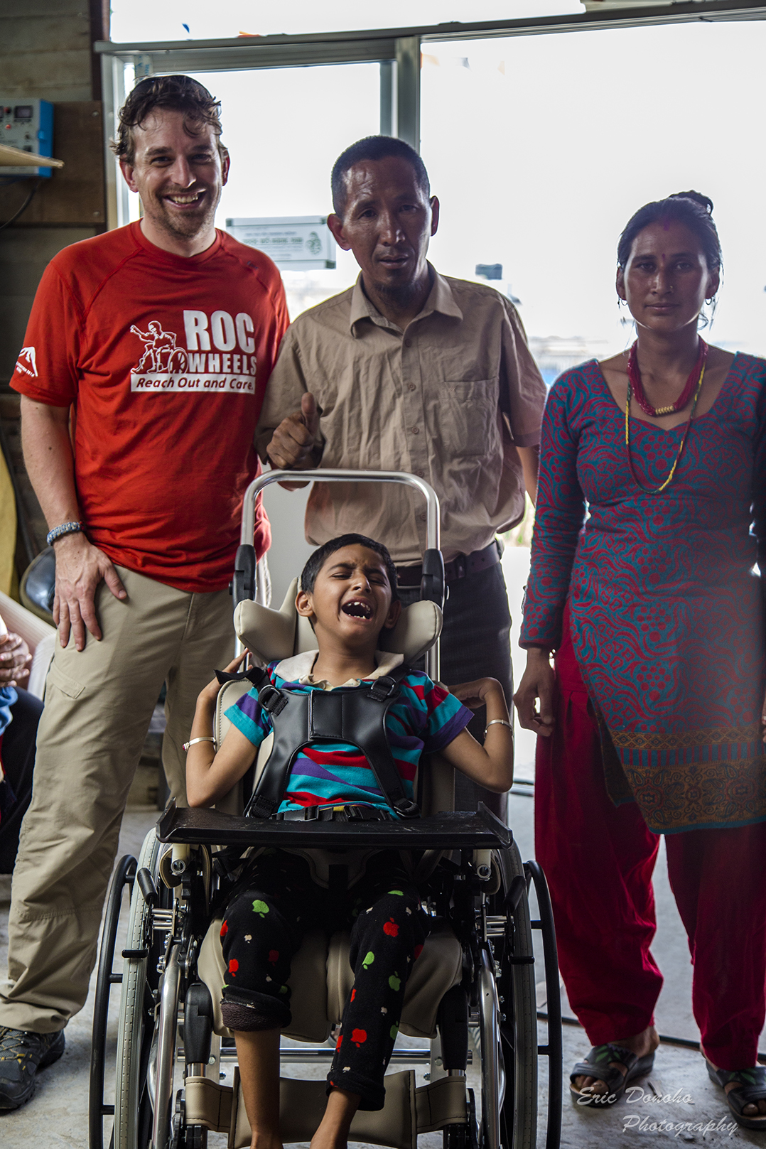 Eric Donoho, left, and Center for Disabled Children Assistance founder Dendi Sherpa pause with Bishnu and his mother. (Submitted photo)